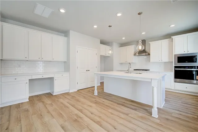 a kitchen with a refrigerator and white cabinets