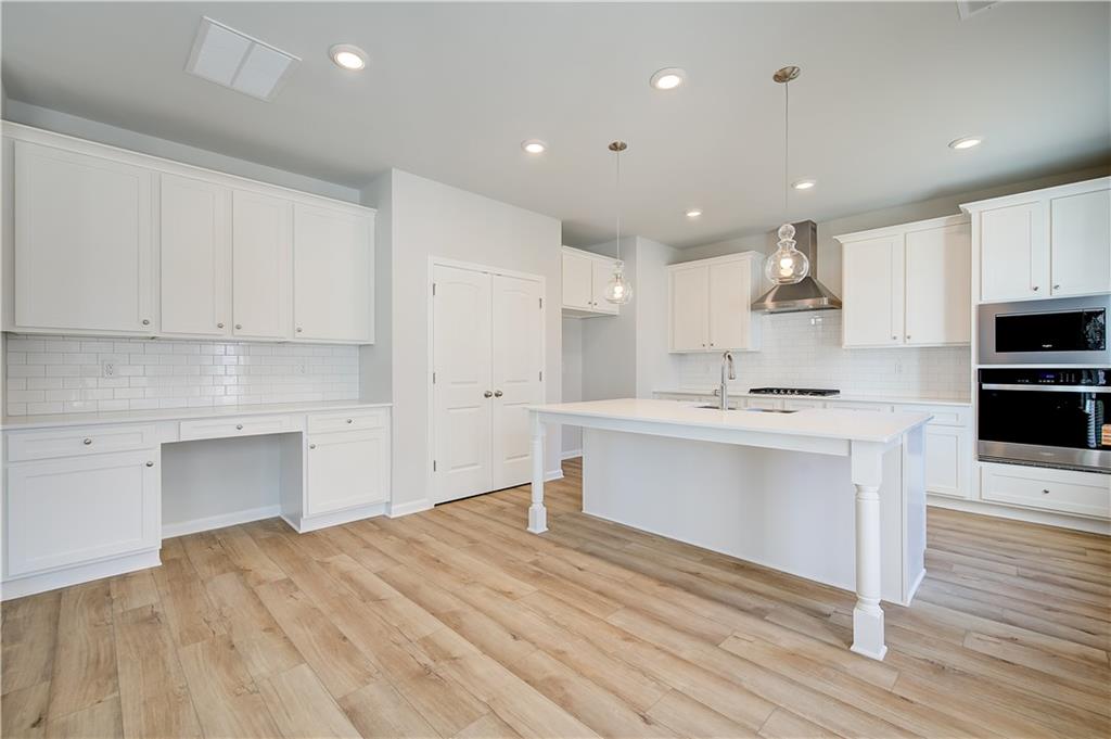 305 Exeter Court Stockbridge, GA 30281 - Photo 12 of 27 a kitchen with a refrigerator and white cabinets