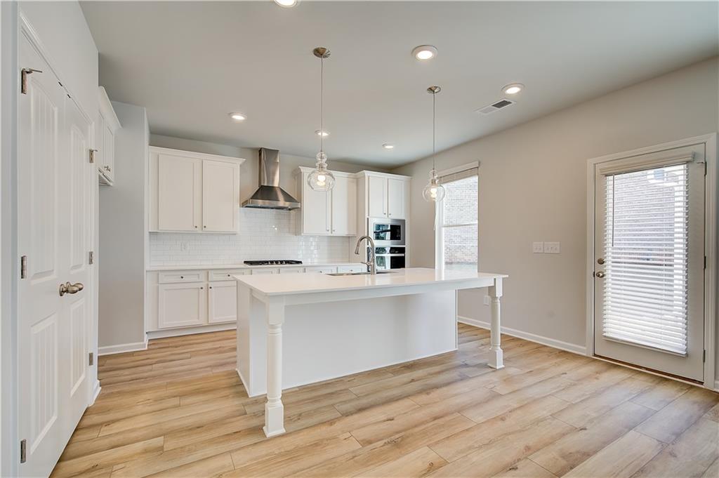 305 Exeter Court Stockbridge, GA 30281 - Photo 14 of 27 a kitchen with white cabinets and white appliances