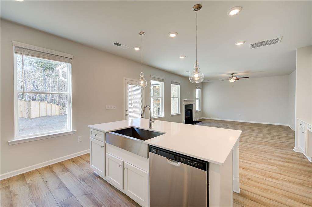 305 Exeter Court Stockbridge, GA 30281 - Photo 15 of 27 a kitchen with a sink chandelier and wooden floor