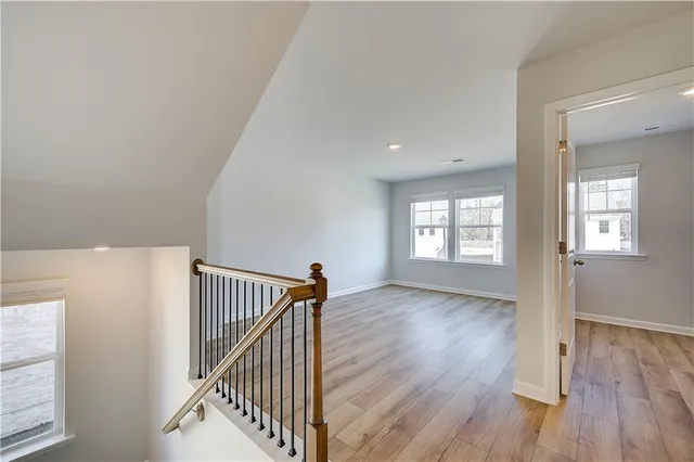 a view of a hallway with wooden floor and stairs