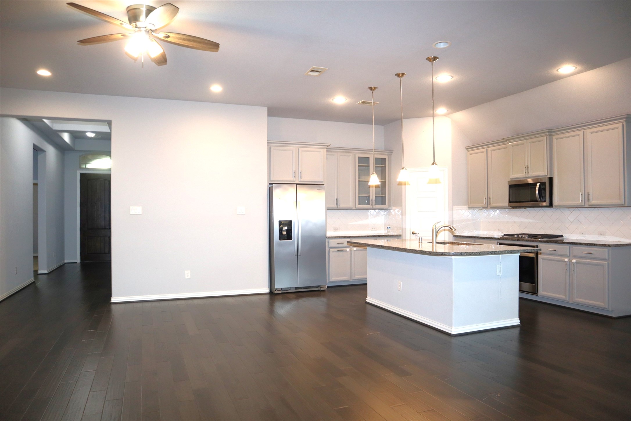 4553 New Country Drive Spring, TX 77386 - Photo 35 of 36 a kitchen with stainless steel appliances granite countertop a refrigerator a sink dishwasher a stove and white cabinets with wooden floor