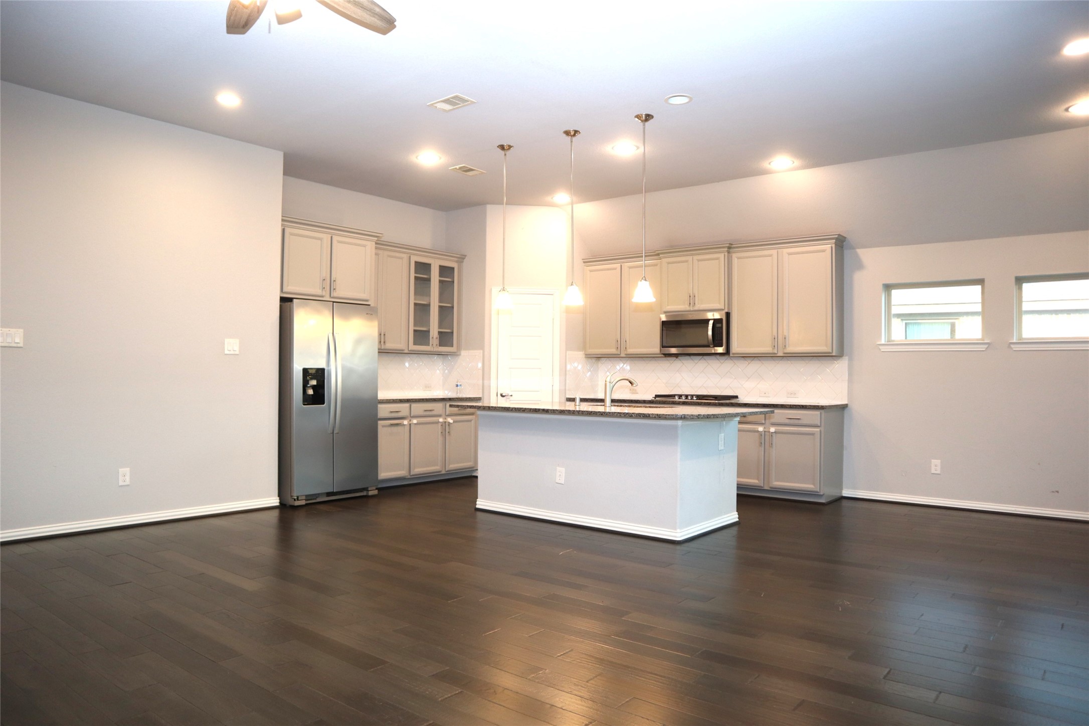 4553 New Country Drive Spring, TX 77386 - Photo 33 of 36 a large kitchen with stainless steel appliances granite countertop a refrigerator a sink dishwasher a stove and white countertops with wooden floor
