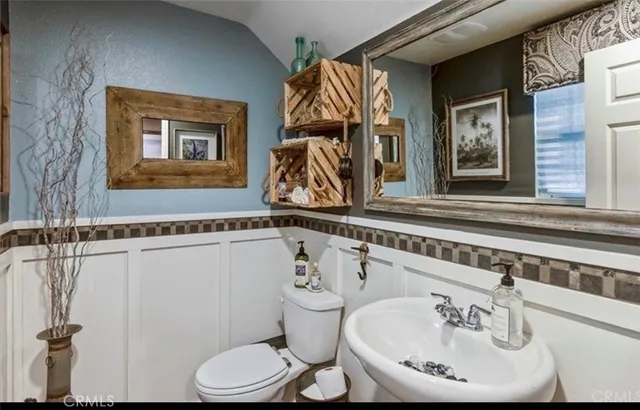 a bathroom with a sink a toilet and a mirror