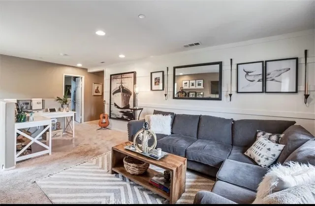 a living room with furniture a couch and kitchen view