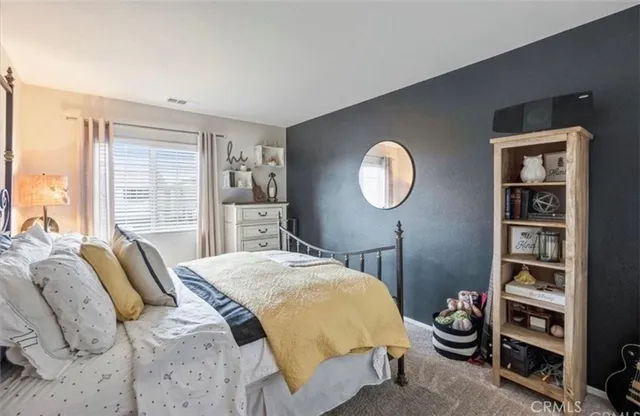 a bed sitting in a bedroom next to a window and closet