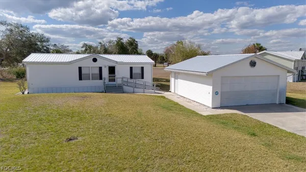 a aerial view of a house next to a yard and a large tree
