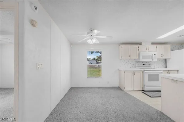 a view of a kitchen with white cabinets and white appliances