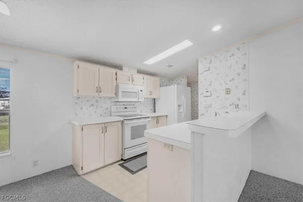 a kitchen with white cabinets and white appliances