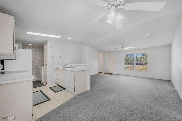 a view of an empty room with a kitchen