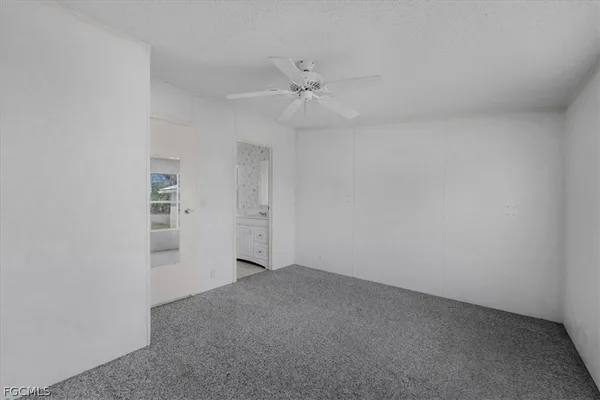 an empty room with closet and windows