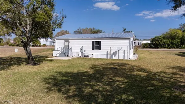 a view of a house with backyard and a tree