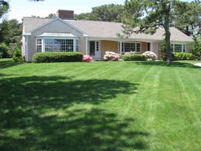 127 Old Salt Works Road Chatham, MA 02633 - Photo 1 of 10 a front view of a house with a garden and trees