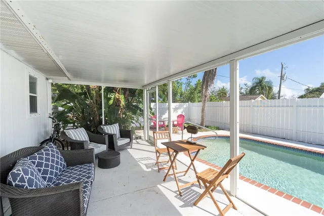 a living room with patio furniture and a garden
