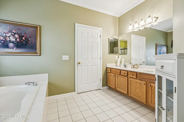 a spacious bathroom with a double vanity sink mirror and bathtub
