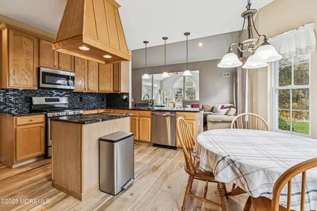 a kitchen with stainless steel appliances granite countertop a sink a stove and a refrigerator
