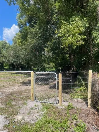 a backyard of a house with lots of plants and trees