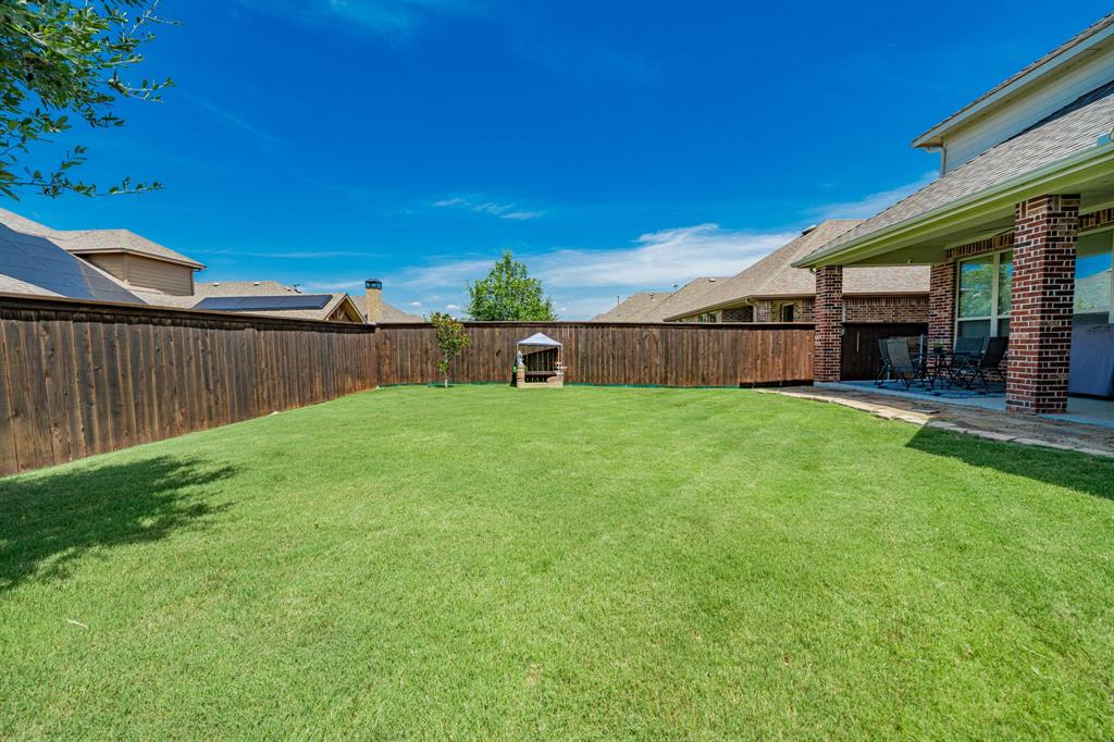 2023 Cutter Crossing Place Wylie, TX 75098 - Photo 15 of 33 a view of a backyard with a garden and tree