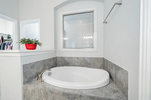 a spacious bedroom with a bed and a ceiling fan