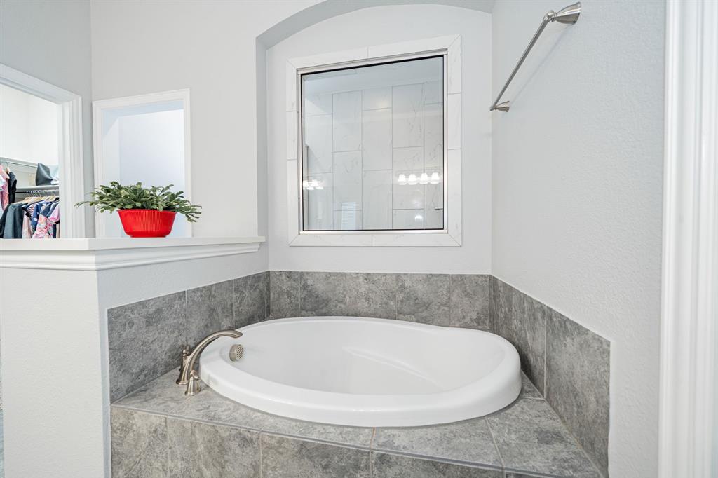 2023 Cutter Crossing Place Wylie, TX 75098 - Photo 22 of 33 a bathroom with a bathtub and a window