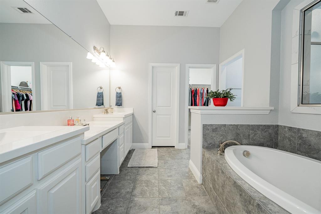 2023 Cutter Crossing Place Wylie, TX 75098 - Photo 24 of 33 a bathroom with a tub sink and mirror