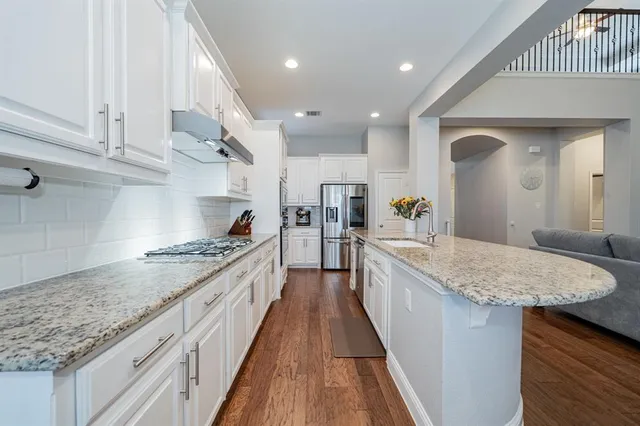 a large living room with stainless steel appliances kitchen island granite countertop a couch and a couch