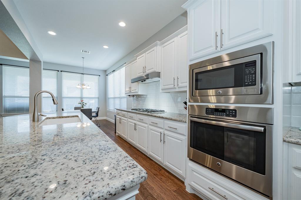 2023 Cutter Crossing Place Wylie, TX 75098 - Photo 7 of 33 a large kitchen with stainless steel appliances granite countertop a stove a sink and a microwave