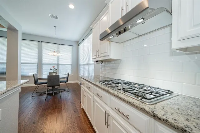 a large kitchen with stainless steel appliances granite countertop a stove a sink and a microwave