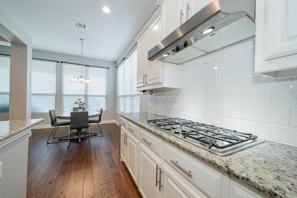 2023 Cutter Crossing Place Wylie, TX 75098 - Photo 8 of 33 a kitchen with stainless steel appliances granite countertop a stove and wooden floors