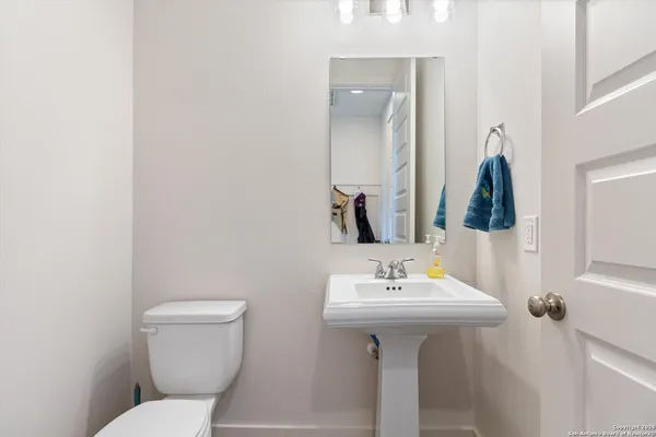 a bathroom with a toilet sink and mirror