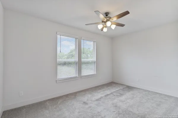 an empty room with window and ceiling fan