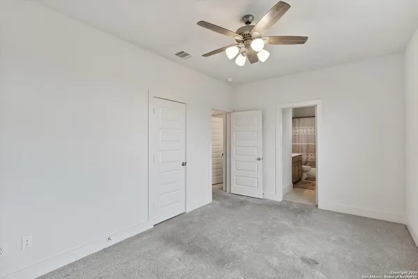 a view of an empty room with a ceiling fan