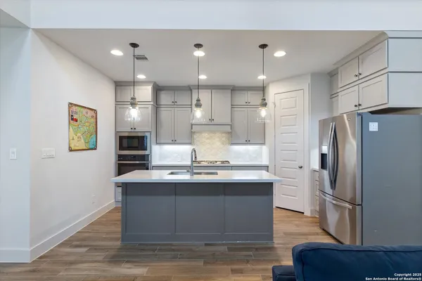 a kitchen with kitchen island stainless steel appliances a sink and a refrigerator