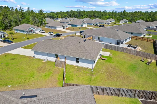 an aerial view of a house with swimming pool and ocean view