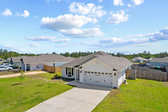 a view of a house with a big yard couches and wooden fence