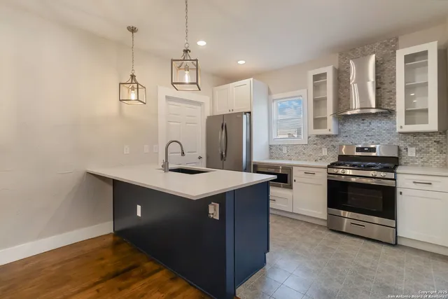 a kitchen with stainless steel appliances granite countertop a sink stove and refrigerator