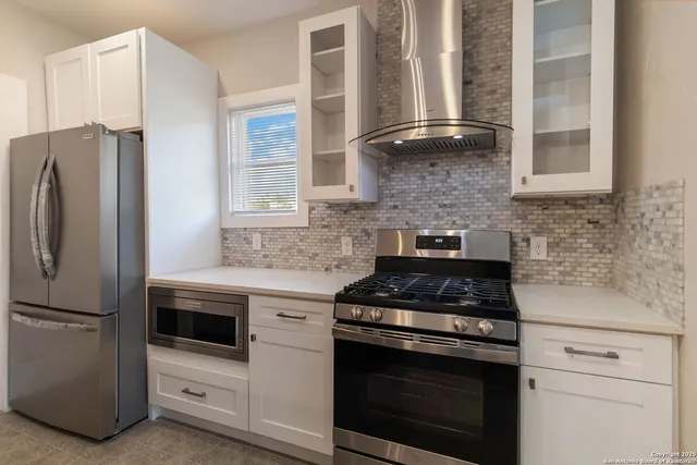 a kitchen with granite countertop a stove and a refrigerator