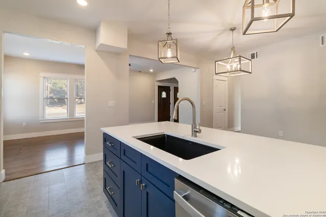 a kitchen with a sink a counter space and wooden floor