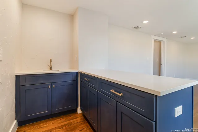 an empty room with wooden floor and a ceiling fan