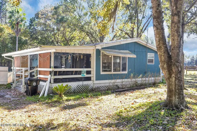 a living room with furniture a bookshelf and a window