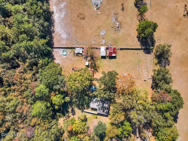 an aerial view of a house with a yard and mountain view in back