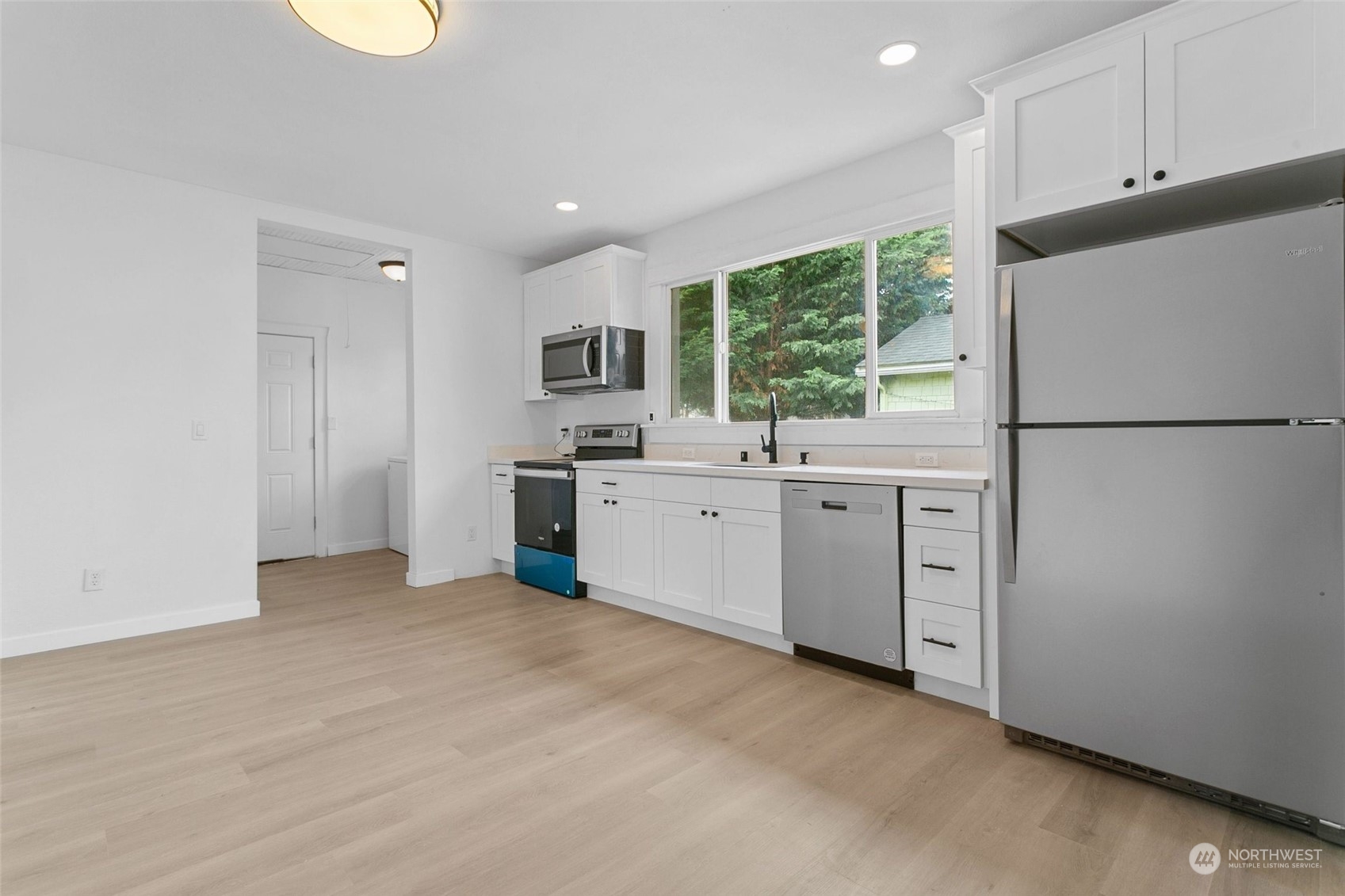 1525 North 3rd Street Renton, WA 98057 - Photo 3 of 38 a kitchen with white cabinets and white appliances