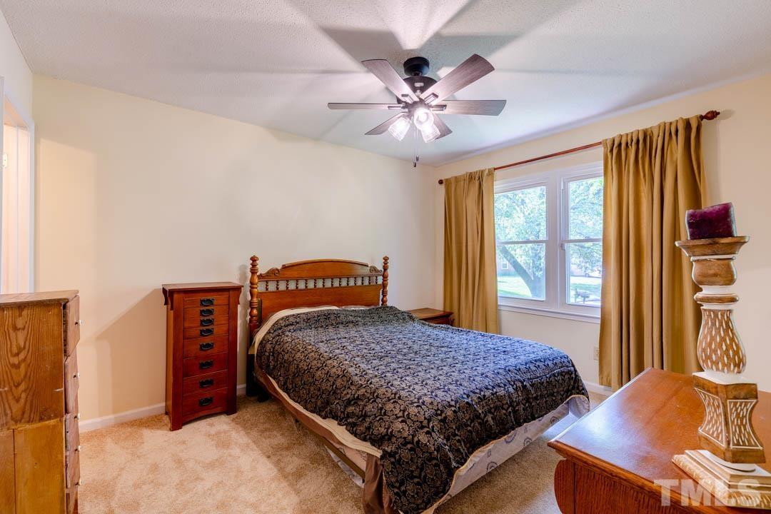 111 Larmack Court Durham, NC 27713 - Photo 16 of 24 a bedroom with a large bed and a chandelier