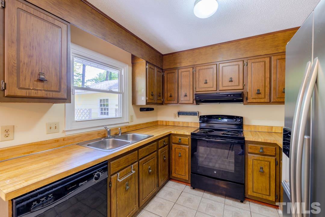 111 Larmack Court Durham, NC 27713 - Photo 6 of 24 a kitchen with stainless steel appliances granite countertop a sink stove and cabinets