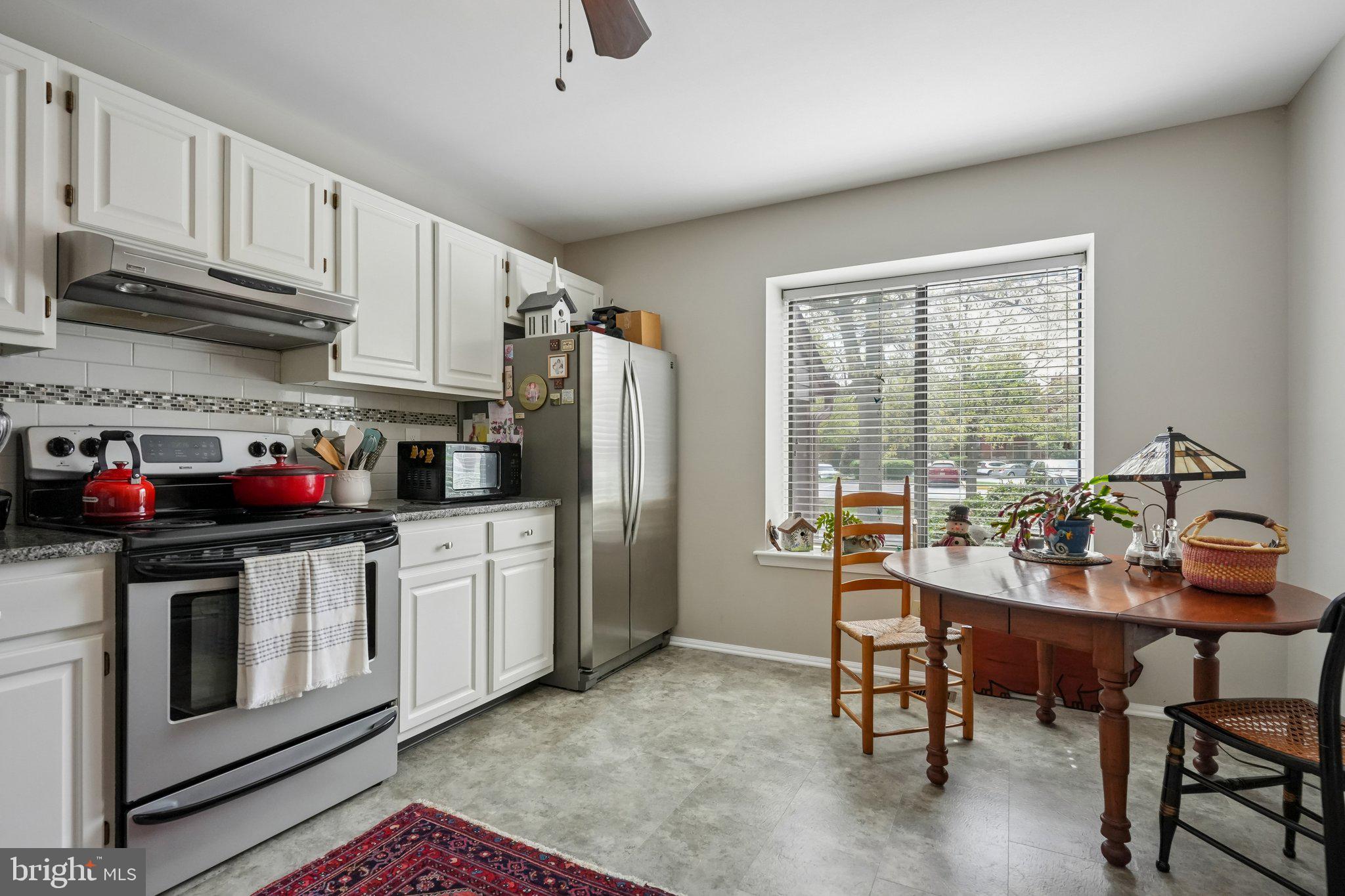 3303A Chadbury Road Mount Laurel, NJ 08054 - Photo 12 of 35 a kitchen with stainless steel appliances granite countertop a stove a refrigerator a kitchen island a table and chairs