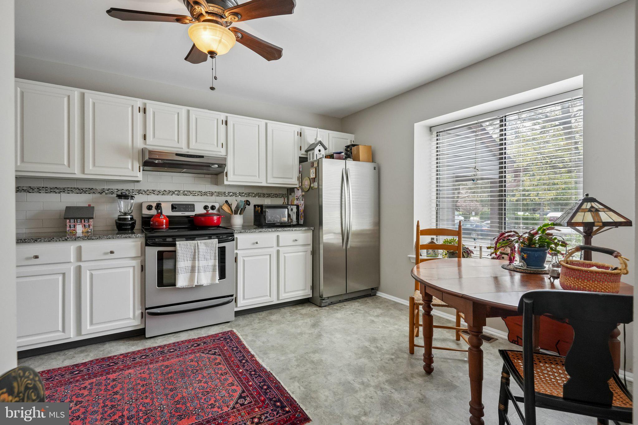 3303A Chadbury Road Mount Laurel, NJ 08054 - Photo 14 of 35 a kitchen with refrigerator cabinets dining table and chairs