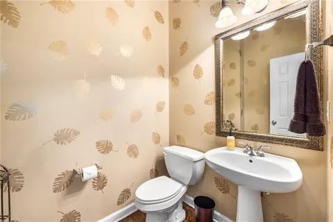 a bathroom with a toilet sink and mirror