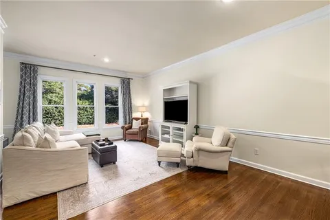 a living room with furniture flat screen tv and a large window