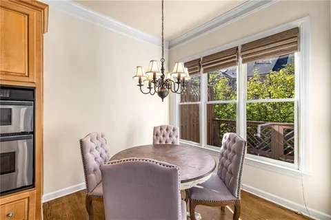 a dining room with furniture a chandelier and wooden floor