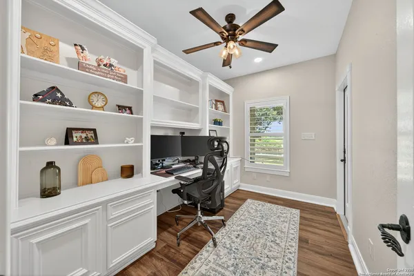 a view of a workspace with furniture and a window